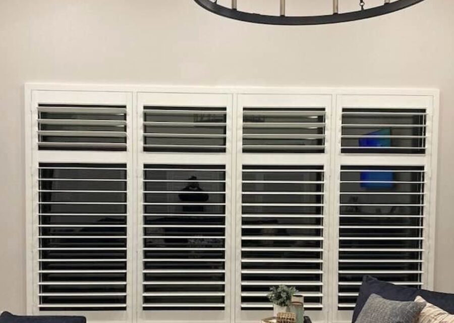 Custom white hardwood plantation shutters installed on a Dallas living-room window